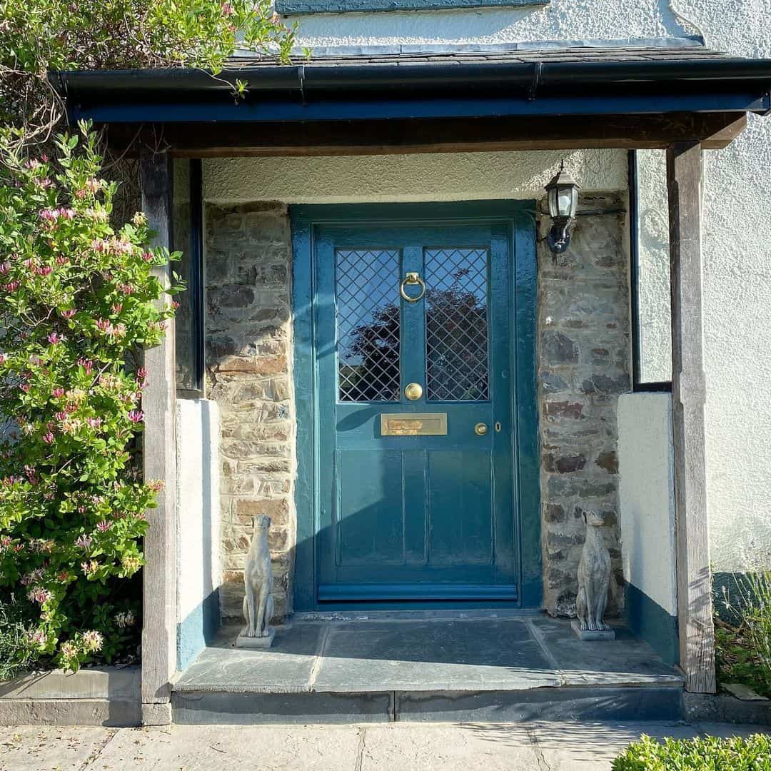 Whimsical Stone Greyhounds Flank a Teal Door