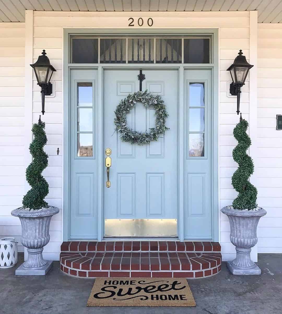 Symmetrical Topiaries Frame a Serene Soft Blue Door