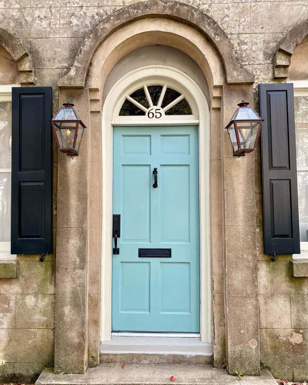 Classic Black Shutters Frame a Welcoming Light Blue Door