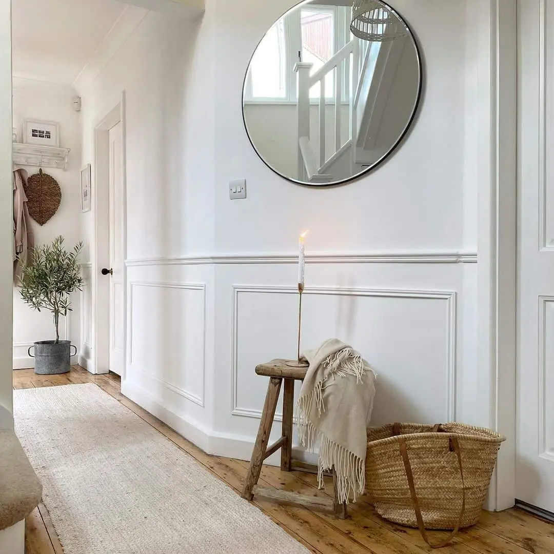 Clean Contrast: Round Mirror Above Paneled Walls