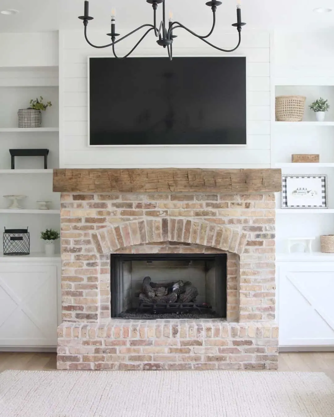 Rustic Wood Beam Mantel Above Brick Fireplace and TV
