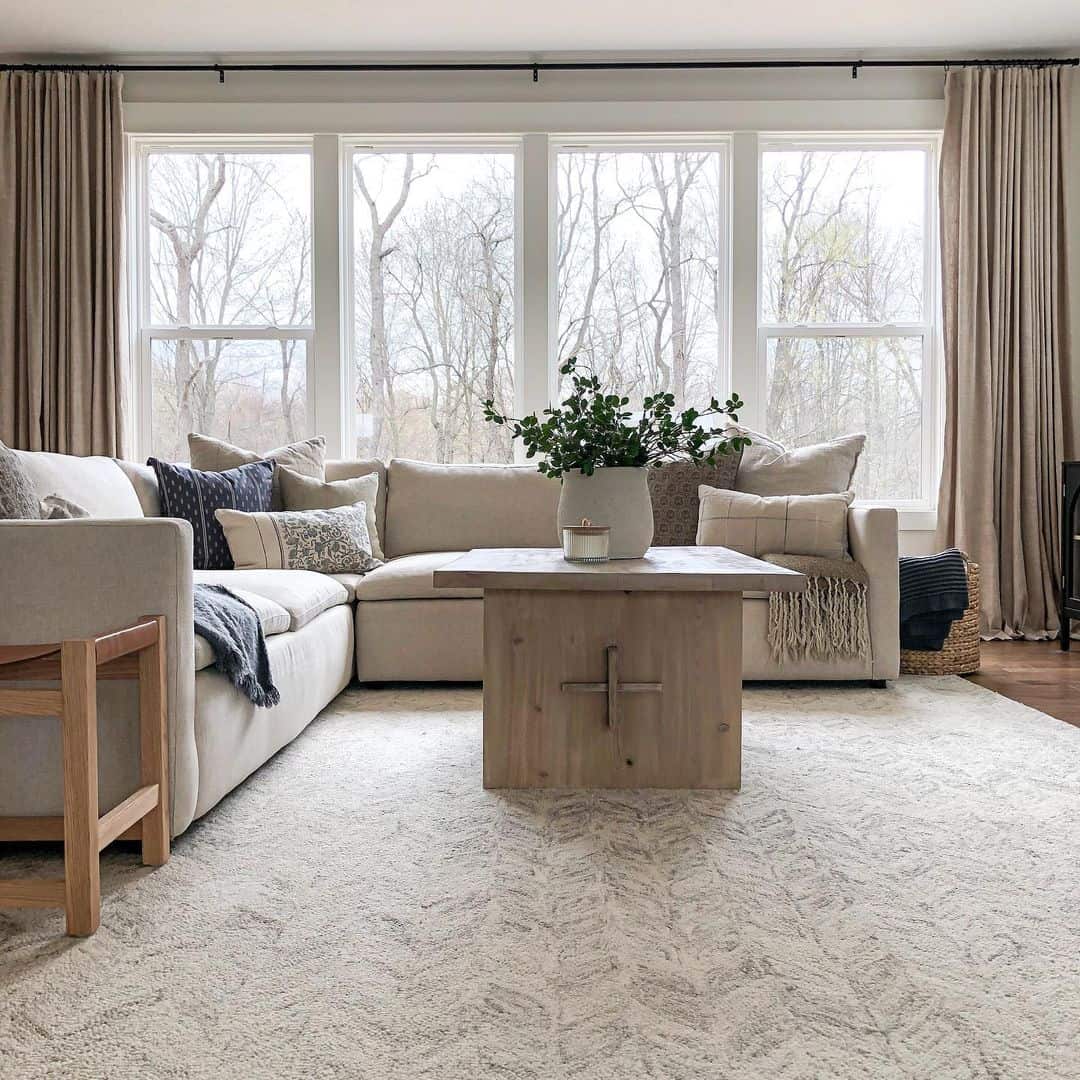 Floor-to-ceiling curtains frame the expansive windows and add a soft, neutral backdrop