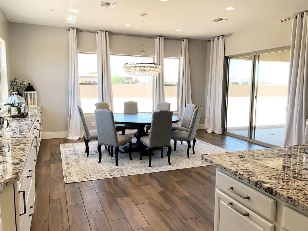 Floor-to-ceiling curtains frame a round dining table