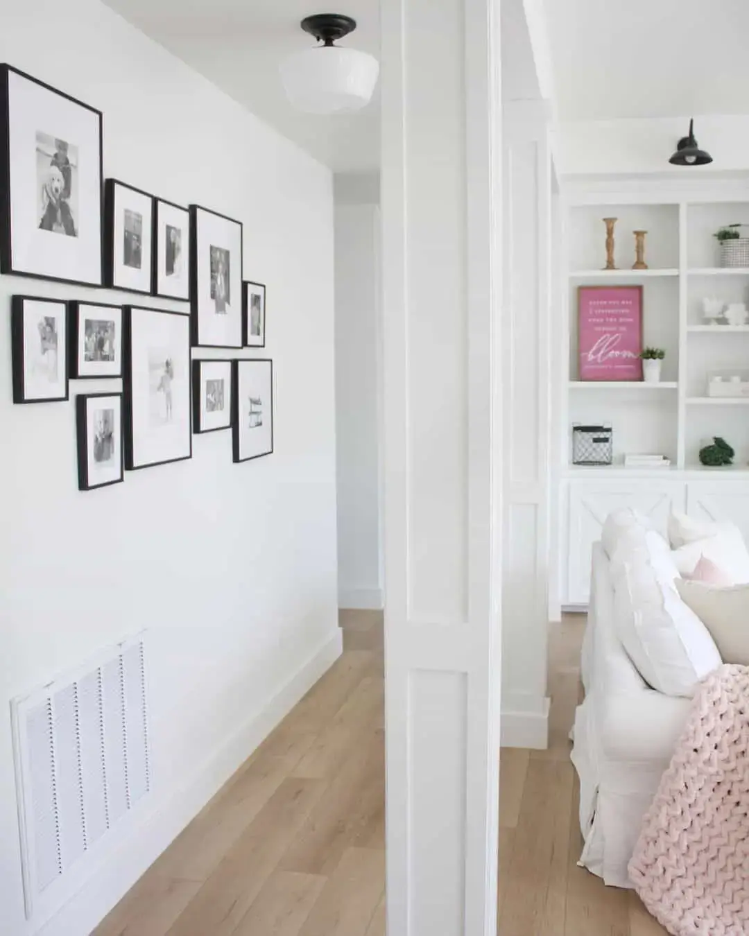 Gallery Wall With Varied Black Frames Creates a Dynamic Hallway