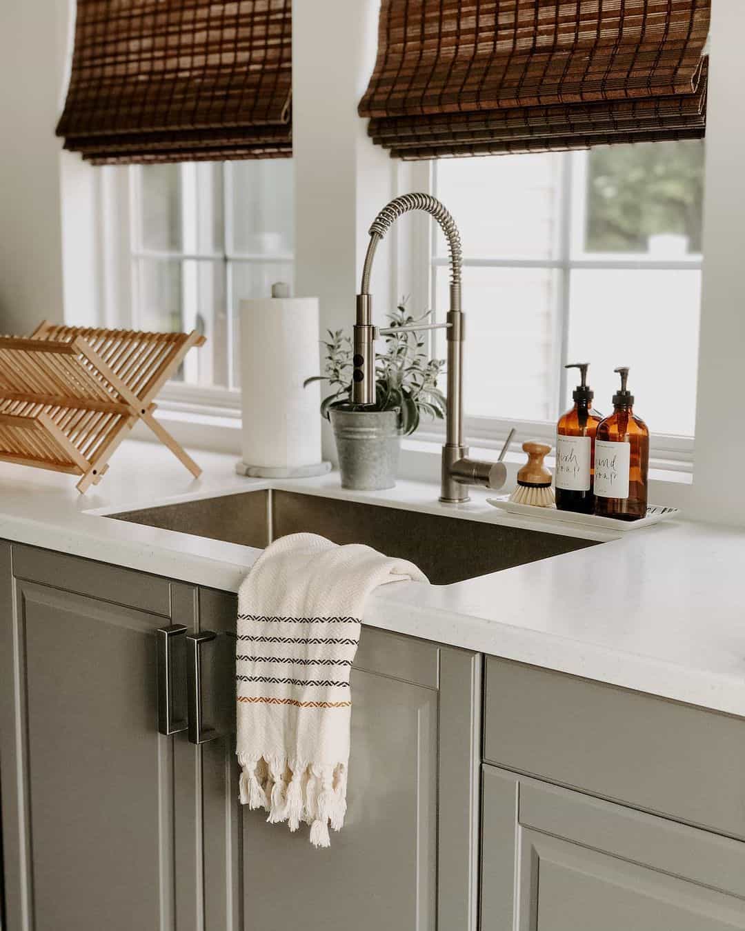 Amber Glass Dispensers Pair With Wooden Brush for a Rustic Sink Area