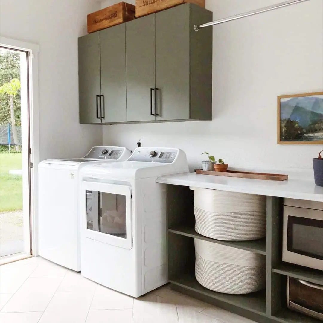Sage Green Cabinets Conceal Clutter Above Washer and Dryer