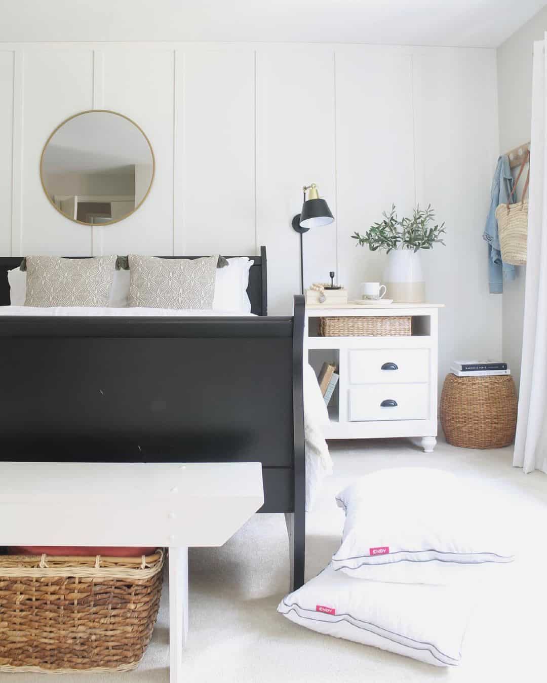 Simple Round Mirror Reflects Light Above A Sleigh Bed