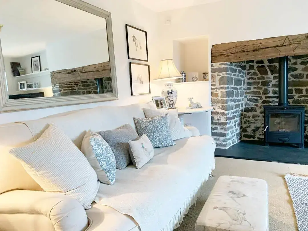 Large Mirror Reflects Rustic Stone Fireplace and Beam