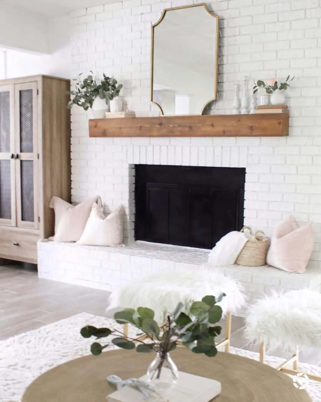 Ornate Gold Mirror Reflects Light Above Wood Mantel