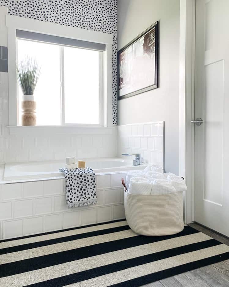 Bold Stripes on a Black and White Rug Ground the Bathroom