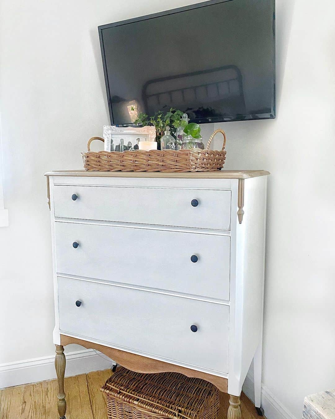 Woven Tray Holds Personal Photos and Greenery Above Dresser