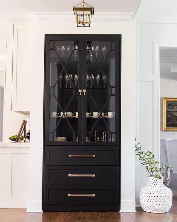 Highlight Geometric Panes and Brass Hardware in a Black Glass-Front Cabinet