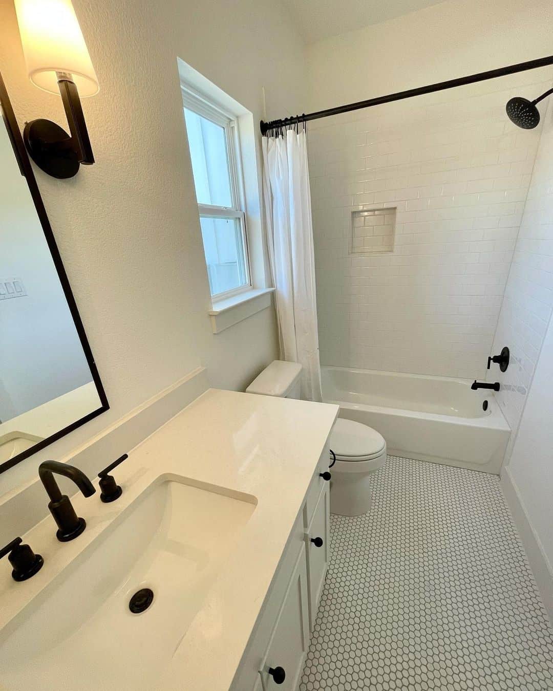 White Hexagon Floor Tiles Add Subtle Pattern to Black and White Bathrooms